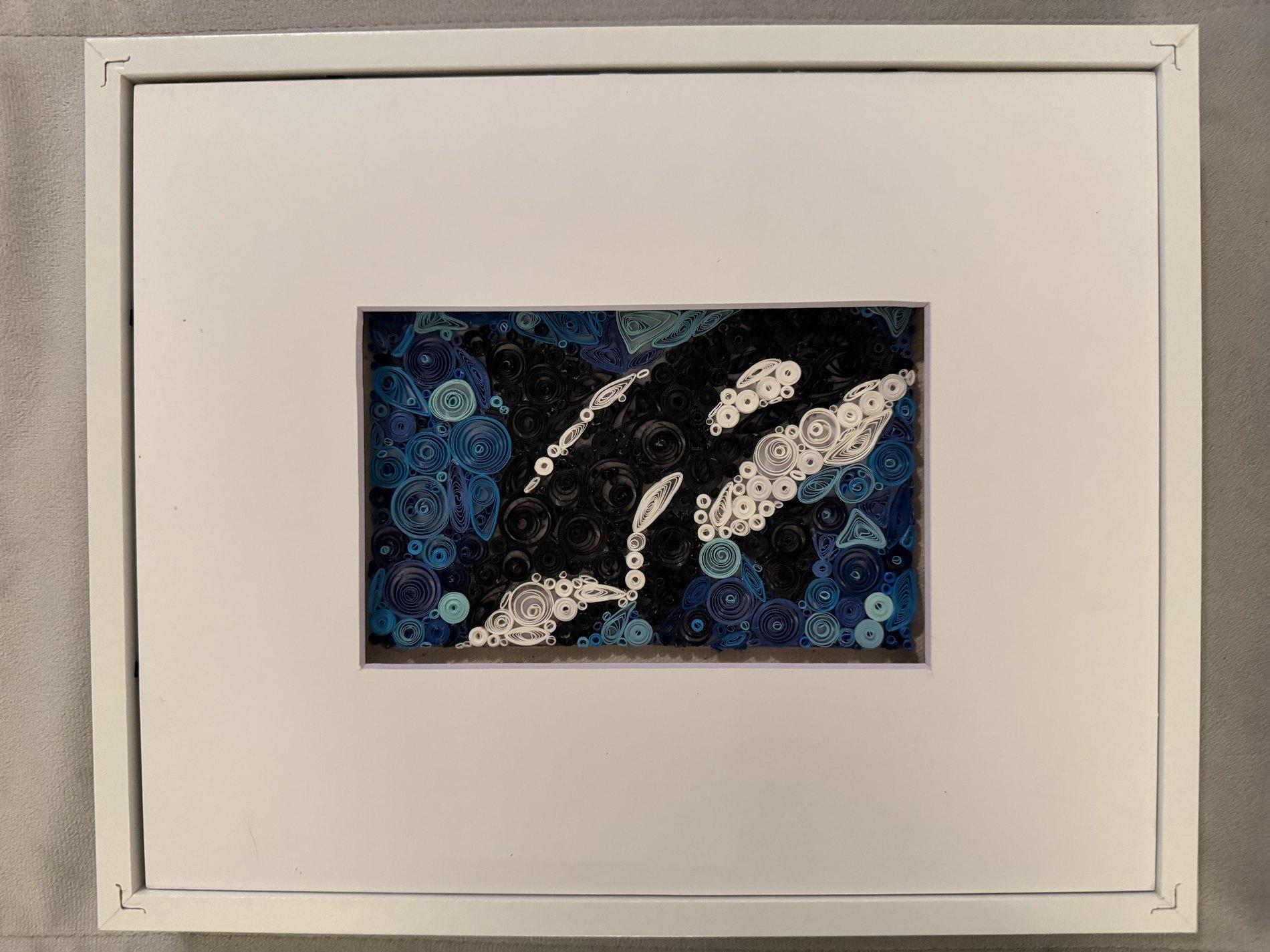Blue and black quilling artwork with white paper shapes