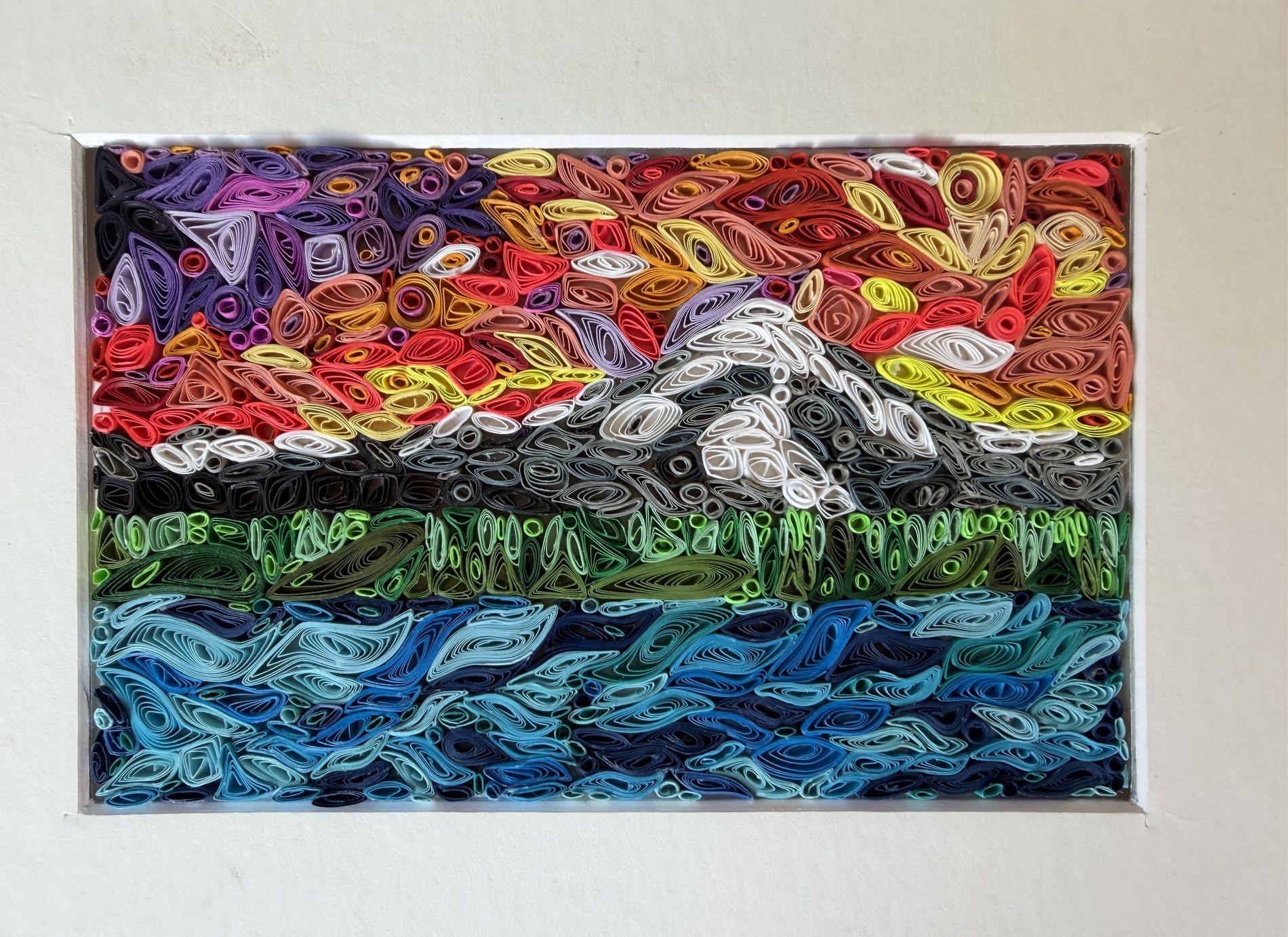 Mount Rainier quilling landscape with a colorful sunset, green shoreline, and blue water