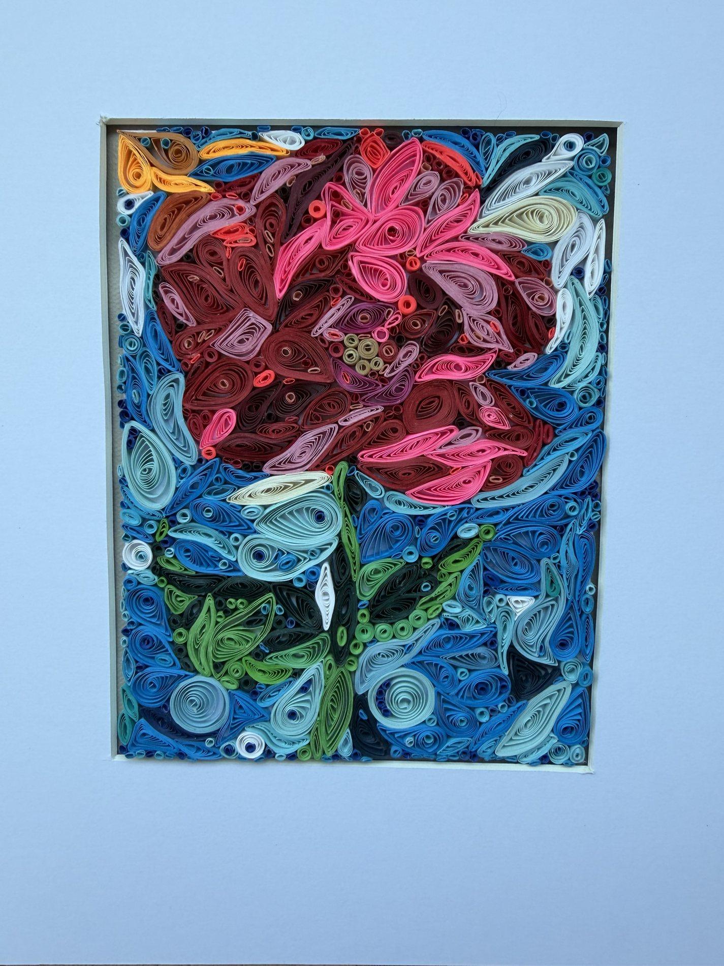 Vibrant abstract quilling artwork in pink, blue, burgundy, and green paper