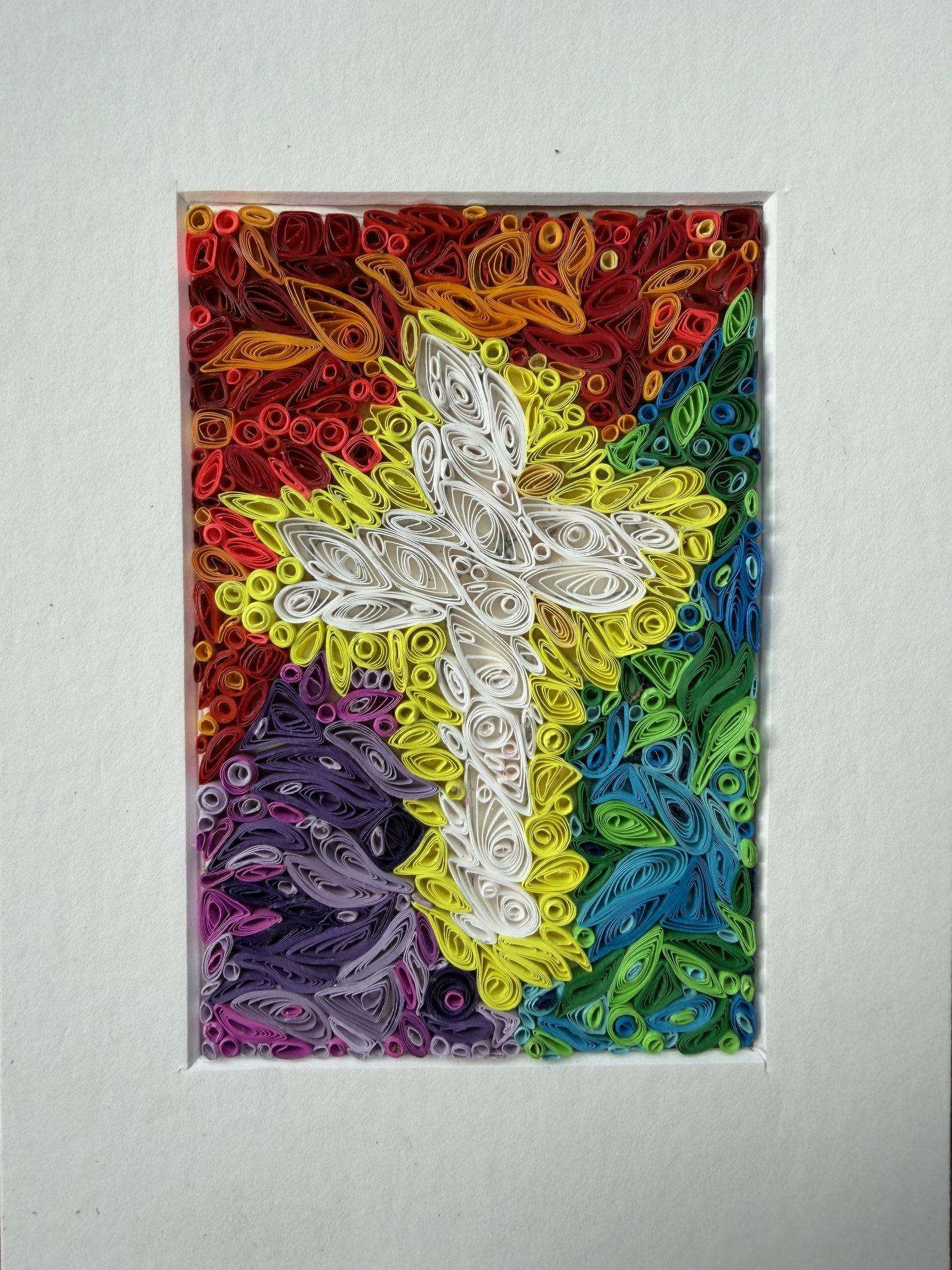 White rabbit quilling artwork surrounded by rainbow-colored paper shapes